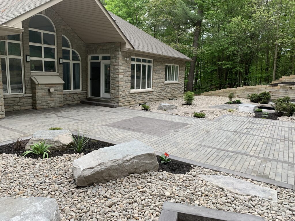 A beautiful backyard with armour stone landscaping and Interlocking Paver Installation in Barrie, ON