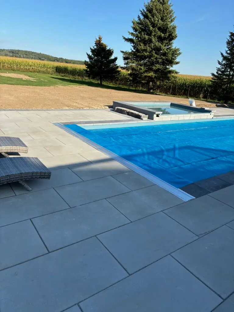 Solar blanket on fiberglass pool. Pool has mesh winter safety cover.